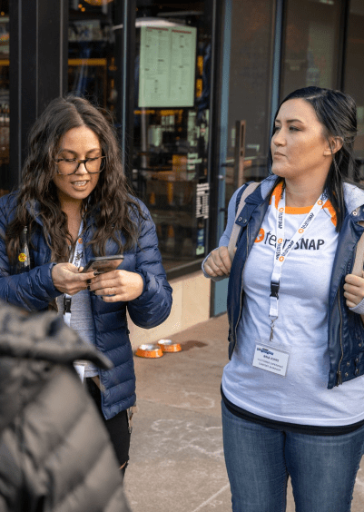 TeamSnappers looking at their phone during an app scavenger hunt in Boulder, Colorado.